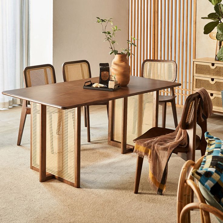 a wooden table with chairs and a vase on top of it in a living room