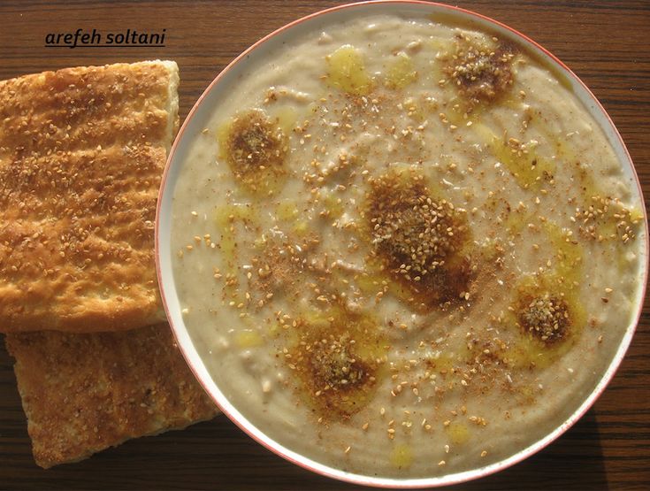 a bowl of oatmeal next to a piece of bread