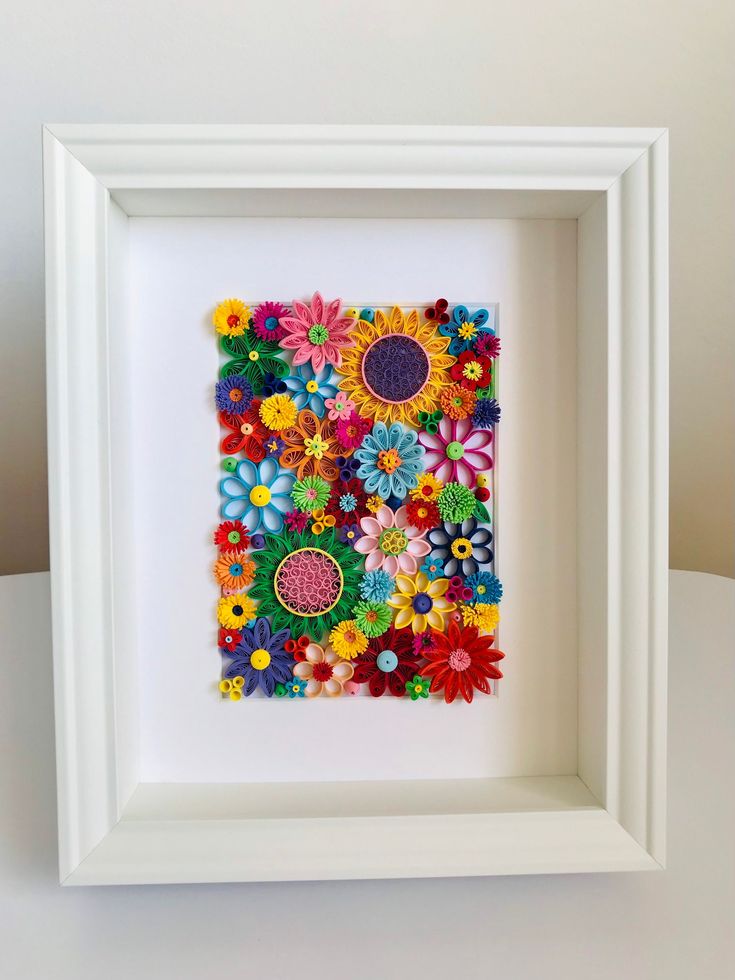 a white frame filled with colorful paper flowers