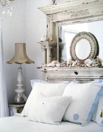 a white bed sitting in a bedroom next to a chandelier