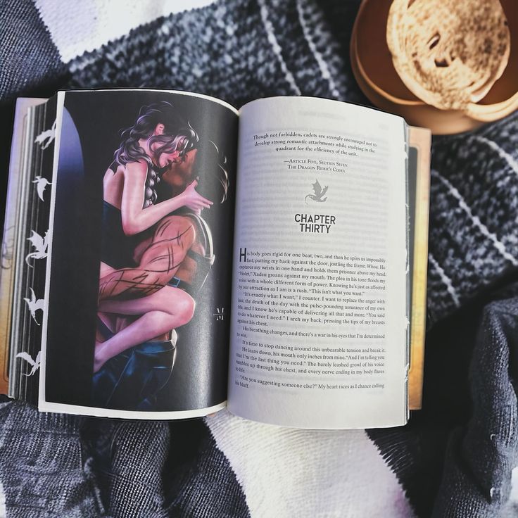 an open book sitting on top of a blanket next to a cup and saucer