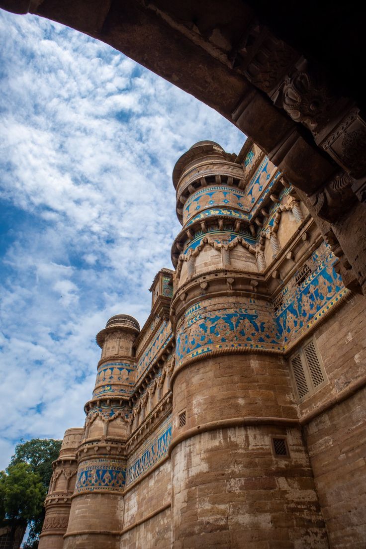 an old building with blue and white designs on it's sides under a cloudy sky