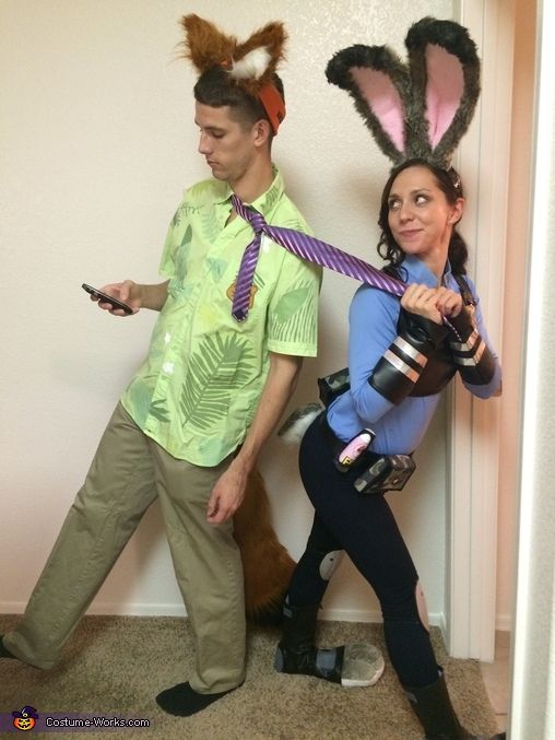 a man and woman dressed up as bunny ears, one holding a camera while the other holds a cell phone