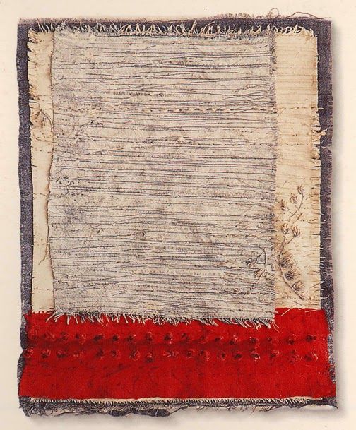 an old piece of cloth with red and white stripes on the bottom, in front of a white wall