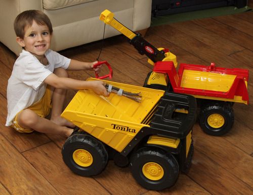 a young boy is playing with a toy truck