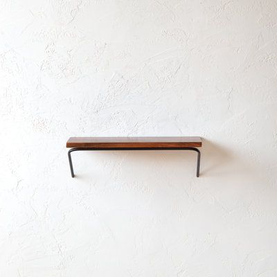 a wooden shelf mounted to the side of a wall