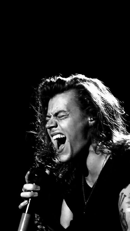 a black and white photo of a woman singing into a microphone with her mouth open