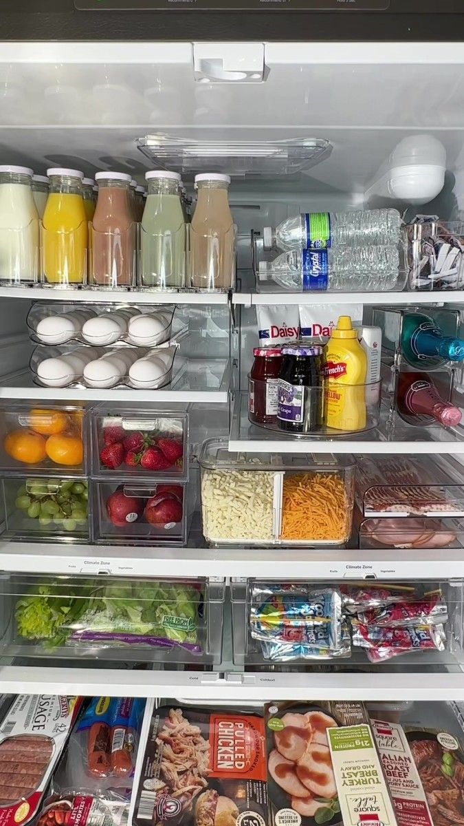 an open refrigerator filled with lots of different types of food and drinks in plastic containers