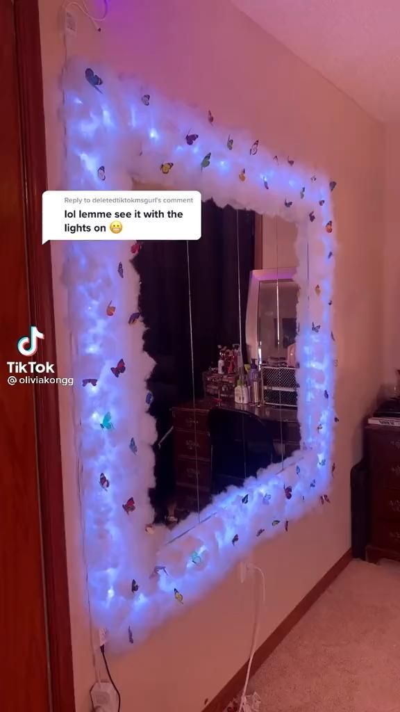 a mirror that has been decorated with blue lights and some decorations on the wall behind it