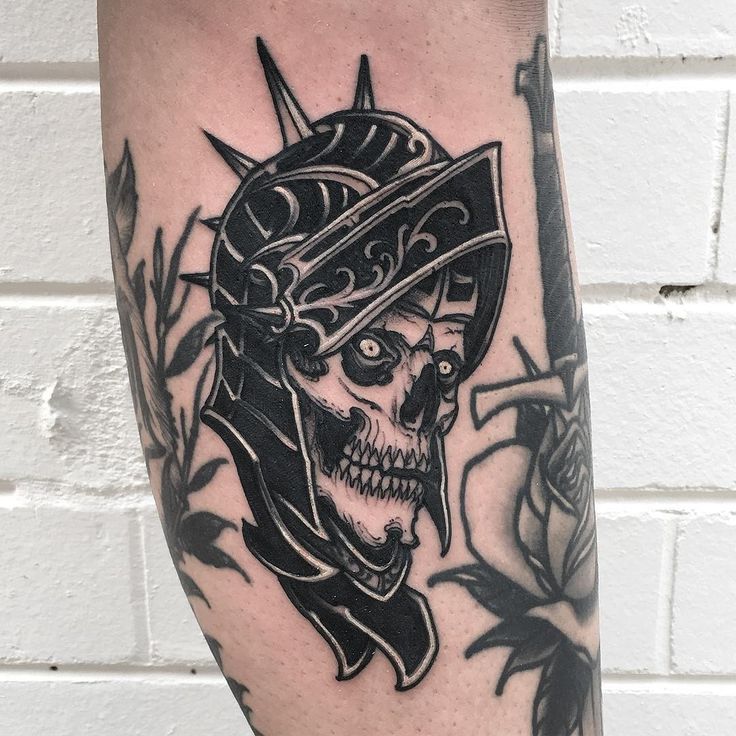 a black and white tattoo with a skull wearing a helmet