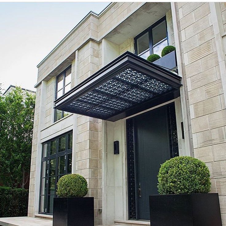 the front door of a large building with two black planters