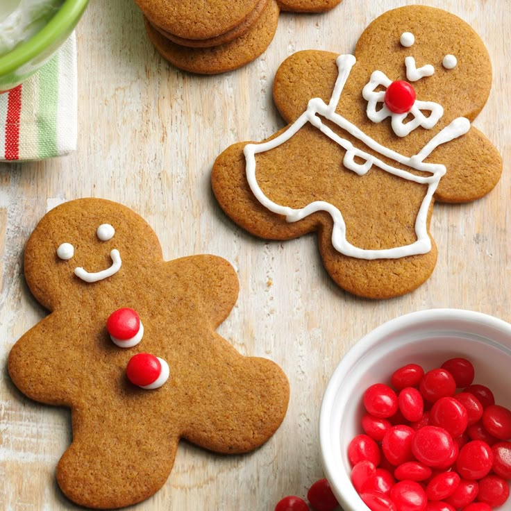 several decorated gingerbreads on a table next to a bowl of candy