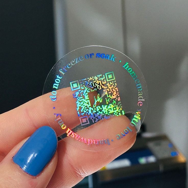 a person holding up a clear sticker with colorful text on it