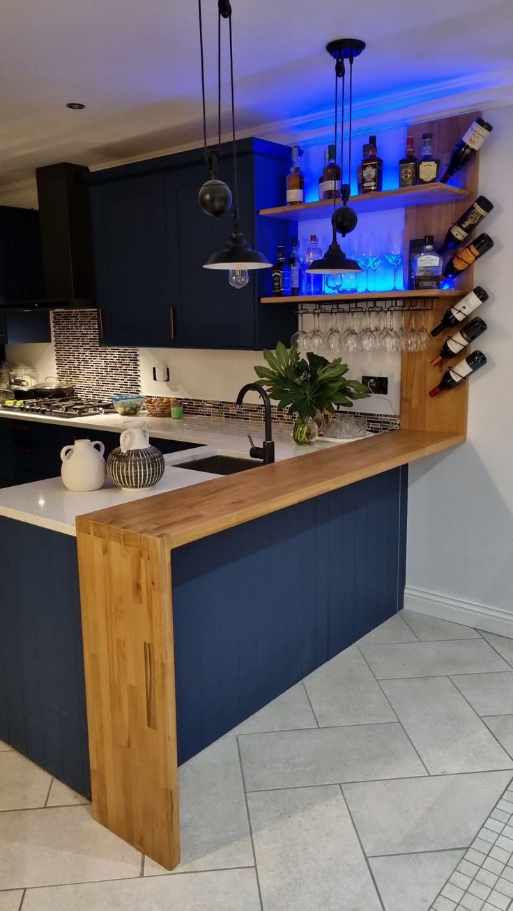 a kitchen with blue lighting and wooden counter tops in the middle of the flooring