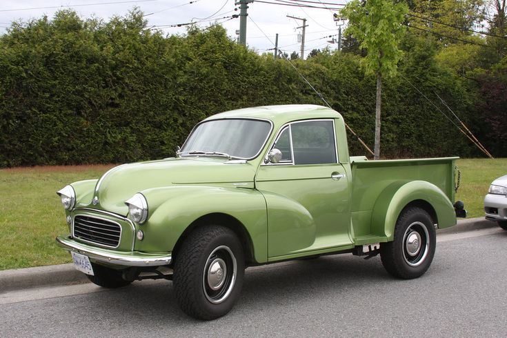 an old pick up truck is parked on the side of the road next to another car