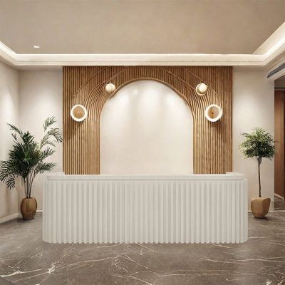 an empty reception room with two planters and a wall mounted screen in the background