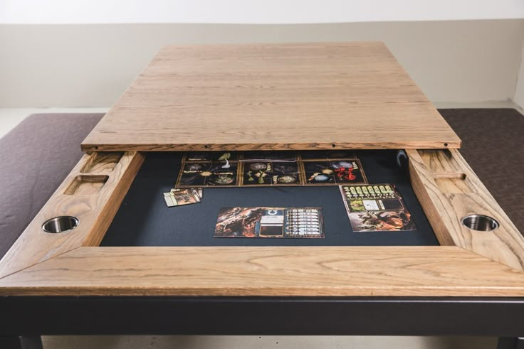 a wooden table with some cards and magnets on it in front of a wall