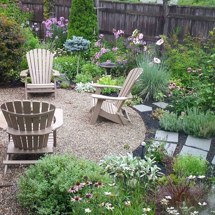 two lawn chairs sitting next to each other in a garden