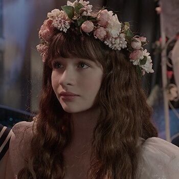 a woman with long hair wearing a flower crown