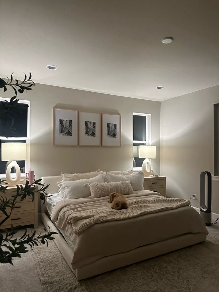 a bed room with a neatly made bed and pictures on the wall