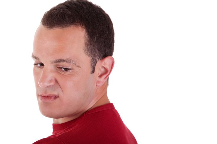 a man in a red shirt looking at his cell phone