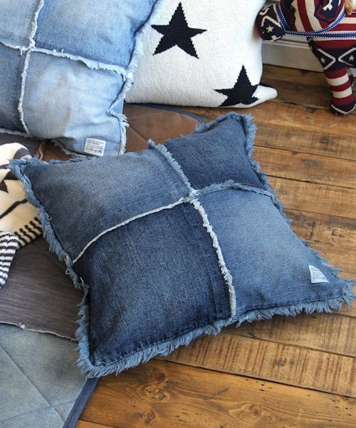 denim pillows with black stars on them sitting on the floor