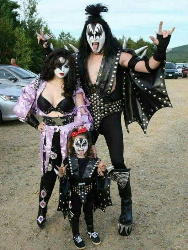 two people dressed up as kiss band members posing for the camera with their hands in the air