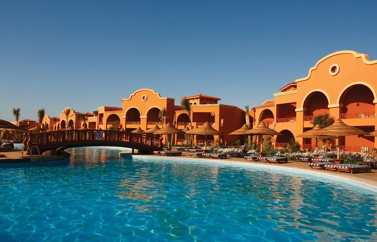 an outdoor swimming pool surrounded by resort buildings