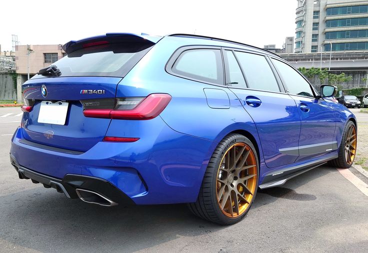 the rear end of a blue car parked in a parking lot