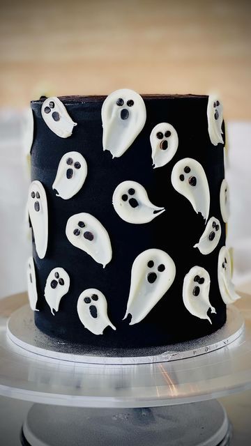 a black and white cake decorated with ghost faces