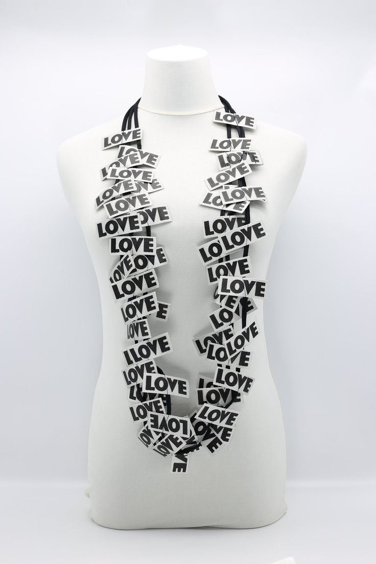 a white mannequin wearing a black and white scarf with words written on it