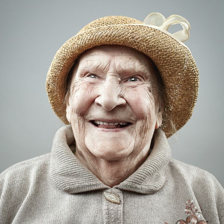 an old woman wearing a hat and smiling