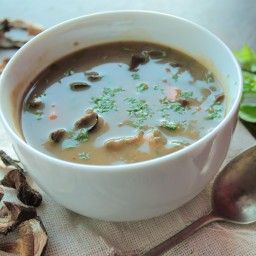 a white bowl filled with soup next to a spoon