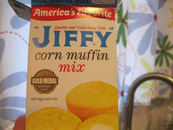 a carton of corn muffin mix sitting on top of a counter next to a sink