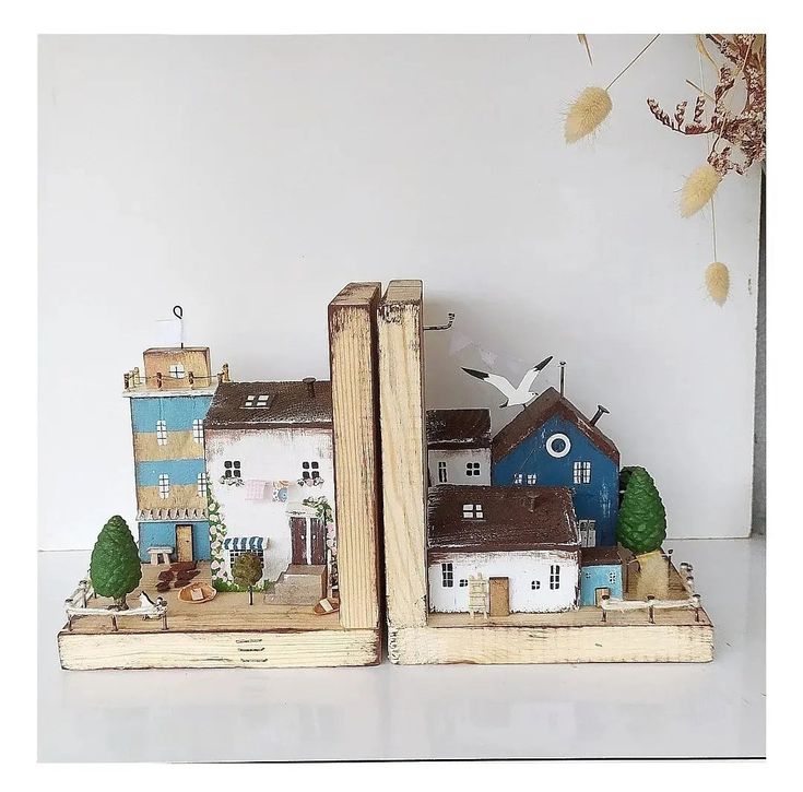 two bookends made out of books with houses and trees in them on a table