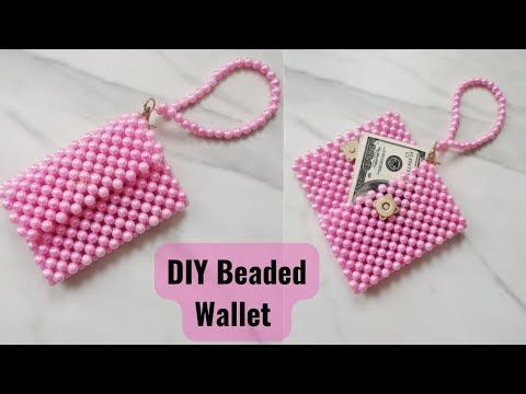 the beaded wallet purse is pink and has a dollar bill hanging from it's side