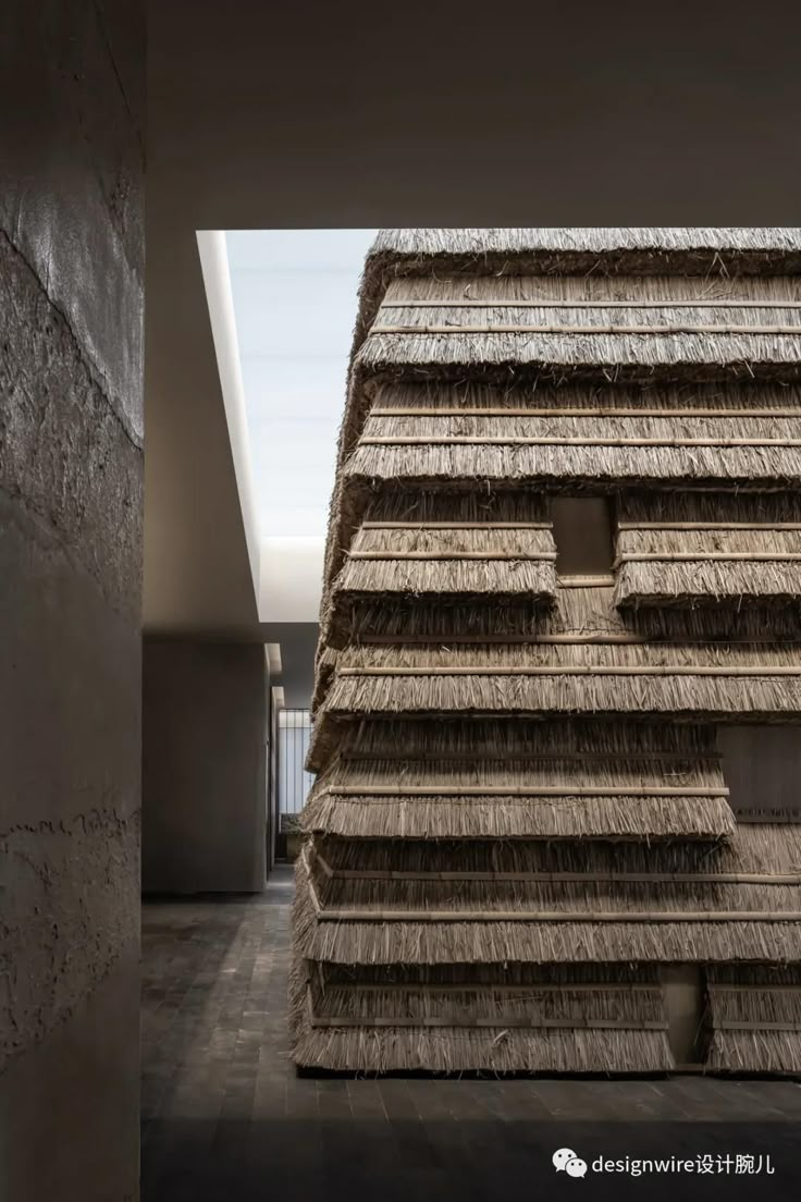 the building is made out of straw and has two windows on each side that look like they are floating in the air