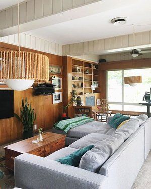 a living room with two couches and a table in front of a tv on the wall