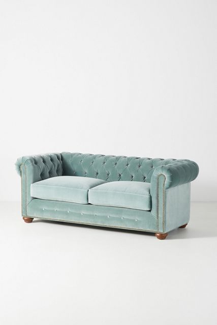 a blue couch sitting on top of a white floor