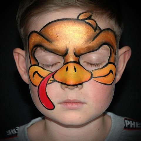 a young boy with his face painted like a cartoon ducky, wearing a nose ring