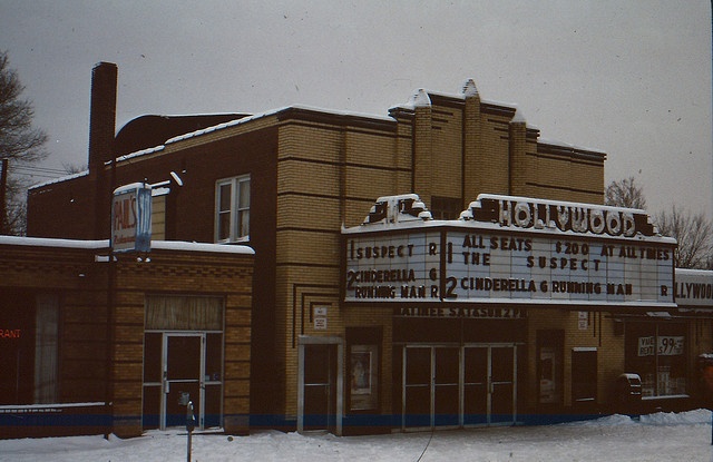 an old movie theater with snow on the ground