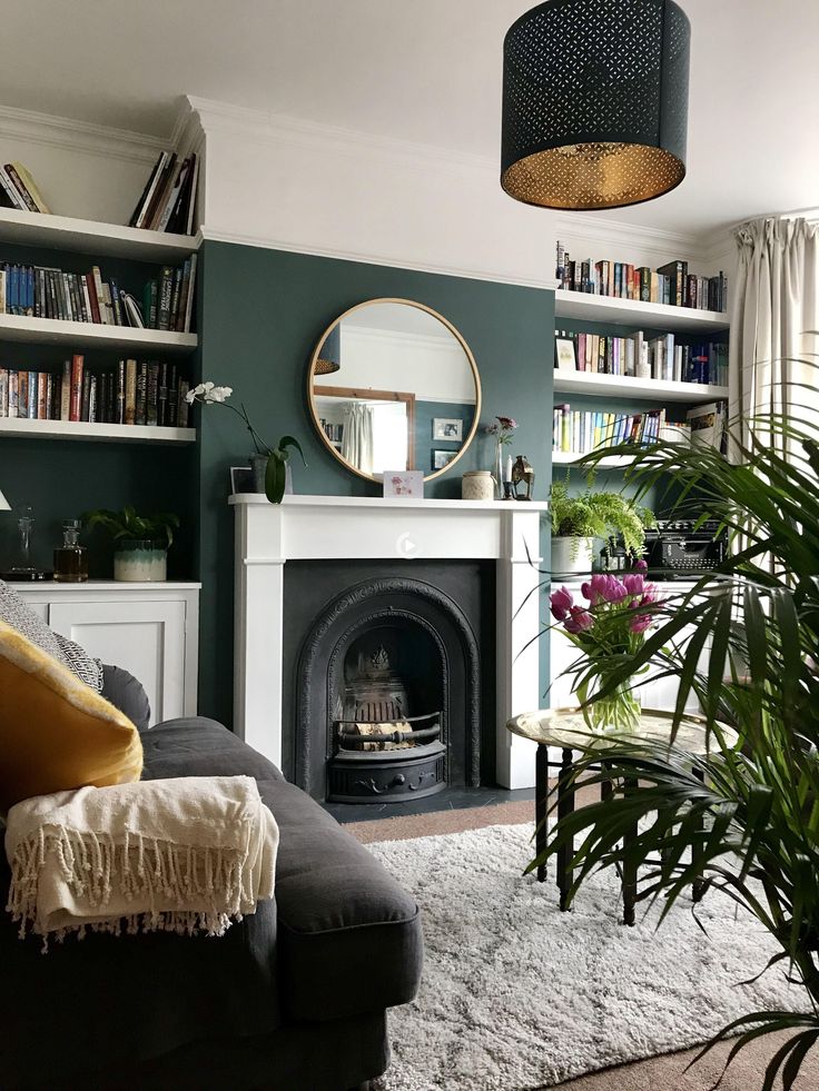 a living room filled with furniture and a fire place in front of a book shelf