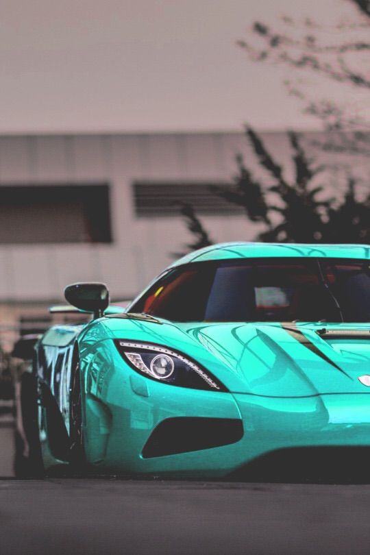 a blue sports car parked in front of a building