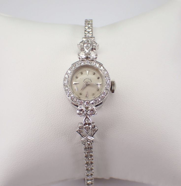 "Vintage Antique Art Deco HAMILTON Watch, dating back to the 1920's. Hand wound Mechanical movement in perfect working condition with a power reserve of approximately 30 hours per wind. The watch is crafted in a 14 Karat White Gold. Both the watch case and the bracelet are white gold and set with genuine Round Diamonds. There are sixty-one genuine round diamonds and two Marquise Diamonds set in the watch case the bracelet band. These diamonds are G in color, SI/VS in clarity and combine to a total weight of 2 1/4 carats. The watch weighs 16.4 grams and measures 6\" in length. This watch will ship promptly in a gift box (not original box), accompanied by an appraisal, valued at $6,495.00. ADDITIONAL REQUESTS If you would like to see more pictures of this item, please let us know and we woul Luxury Timeless Diamond White Watch, Luxury Wedding Jewelry And Watches With Bracelet Strap, Luxury Vintage Diamond Watch With Subdials, Luxury Victorian Style Watch, Luxury Vintage Silver Watch Accessories, Luxury Victorian Style Watch With Round Dial, Luxury Vintage Rectangular Watch Accessories, Luxury Antique Formal Watch Accessories, Art Deco Ladies