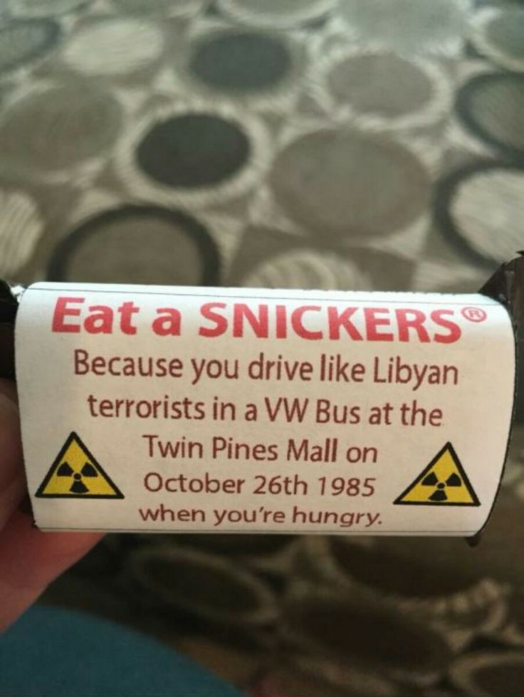 someone holding up a sign that says eat a snickkers because you drive like libyan