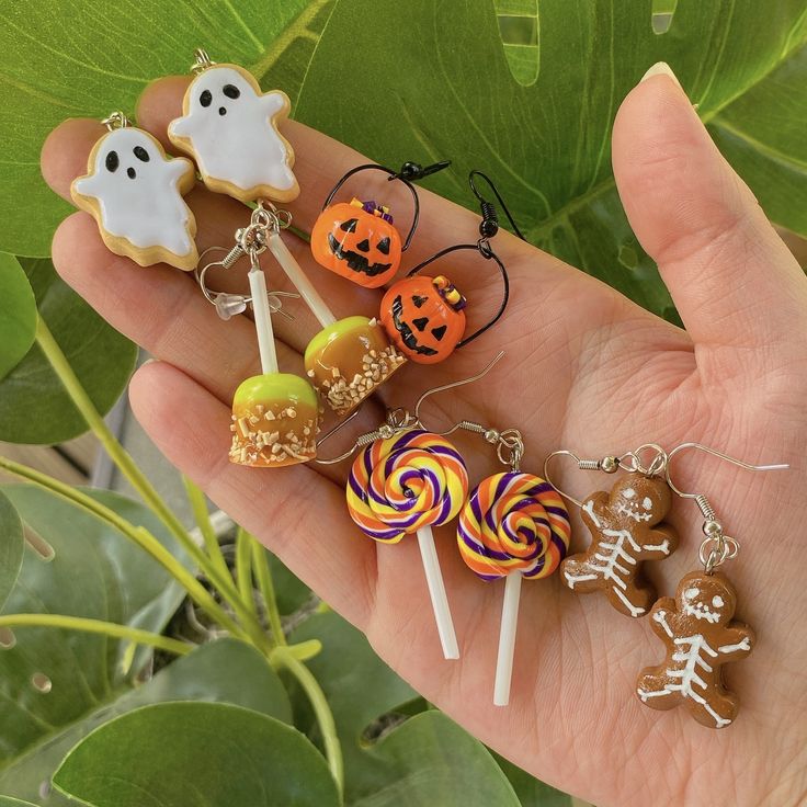 a hand holding several halloween themed lollipops