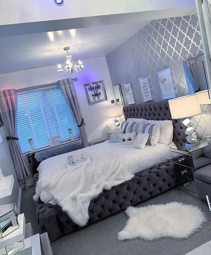 a bedroom with a bed, chair and chandelier in the middle of it