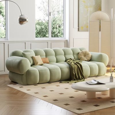 a living room filled with lots of furniture and decor on top of a hard wood floor