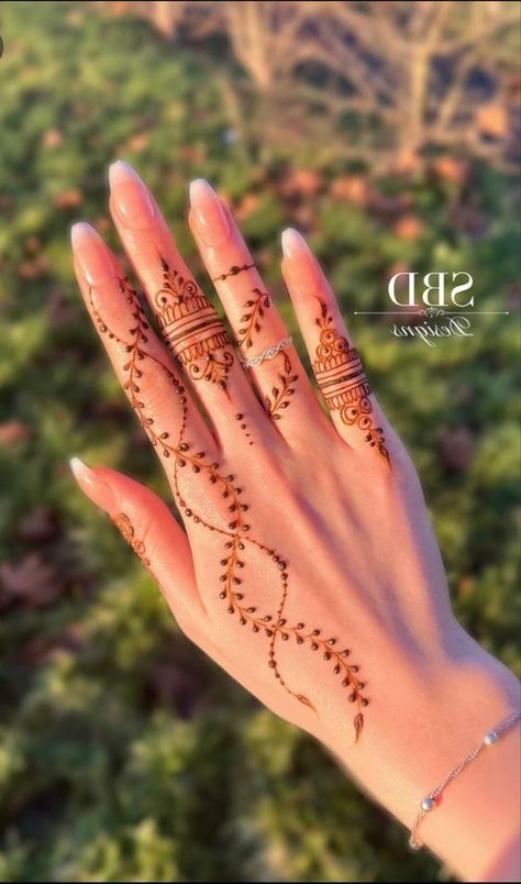 a woman's hand with henna tattoos on it