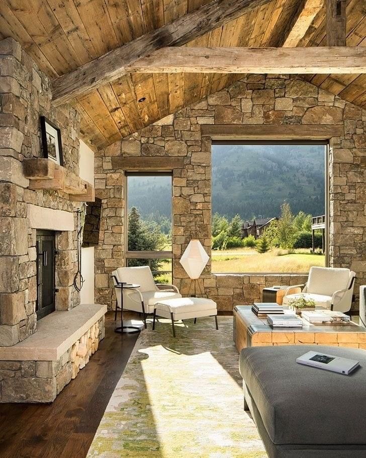 a living room filled with furniture and a stone fireplace